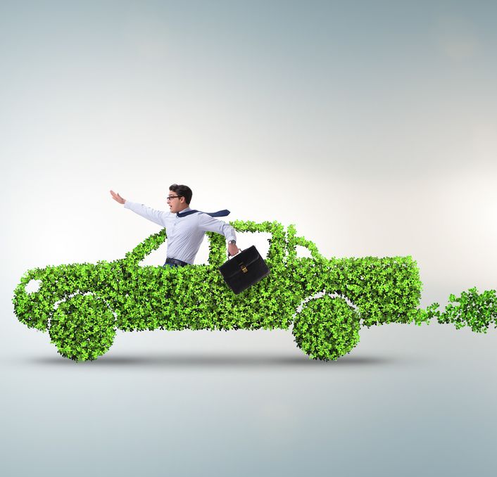 Man driving car made of green leaves